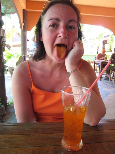 Tracy's drink changes her tongue to match her vest and the awning... clever...