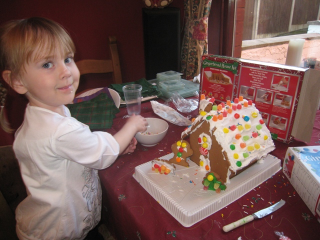 Olivia proudly shows off her gingerbread house